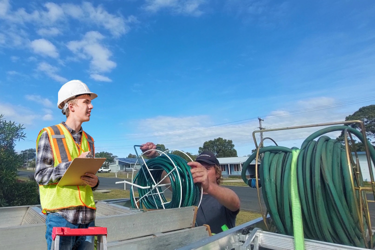 narooma gutter cleaning expert prepares his hose system after gutter rinsing.