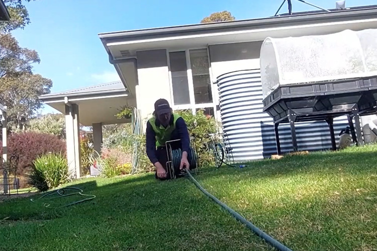 
Wrapping up his daily work, the narooma downpipe cleaner is neatly storing his hose.